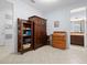 Hallway with tiled floor featuring a large wardrobe, antique desk, and a bathroom view at 887 Daisy Hill Ct, Apopka, FL 32712