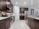 Modern kitchen with granite countertops, stainless steel appliances, and dark brown cabinetry at 887 Daisy Hill Ct, Apopka, FL 32712