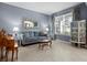 Bright living room with a comfortable blue sofa, piano and elegant decorative accents at 887 Daisy Hill Ct, Apopka, FL 32712