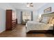 Bedroom featuring an armoire, sitting area, and a large bed with blue and beige comforter and decorative pillows at 887 Daisy Hill Ct, Apopka, FL 32712