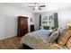 Comfortable bedroom featuring a large bed, window view, ceiling fan, and dark wood armoire at 887 Daisy Hill Ct, Apopka, FL 32712