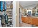 Bathroom featuring double sinks, wood cabinets, and access to the closet at 9150 Se 153Rd Pl, Summerfield, FL 34491