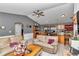 Inviting living room featuring a ceiling fan, comfortable seating, and a seamless flow into the kitchen at 9150 Se 153Rd Pl, Summerfield, FL 34491