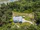 Expansive aerial view of a property with a large backyard, screened-in pool, and additional shed surrounded by greenery at 9905 Skylark Ln, Groveland, FL 34736