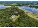 Breathtaking aerial view of a lakefront estate surrounded by lush greenery and serene waters at 9905 Skylark Ln, Groveland, FL 34736