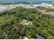 Majestic aerial view showcasing a residence nestled within a lush, green landscape near a lake, highlighting its tranquil setting at 9905 Skylark Ln, Groveland, FL 34736