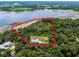 Stunning aerial view of a lakefront home with lush landscaping and private shoreline at 9905 Skylark Ln, Groveland, FL 34736