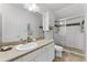 Well-lit bathroom with white cabinetry, solid surface countertops, and a glass-enclosed shower at 9905 Skylark Ln, Groveland, FL 34736