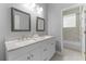 Bathroom featuring double sinks, granite countertops, modern fixtures and tiled floors at 9905 Skylark Ln, Groveland, FL 34736