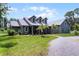 Inviting home with dormer windows, featuring a well-kept lawn and flourishing landscaping at 9905 Skylark Ln, Groveland, FL 34736