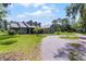 Charming home featuring a long gravel driveway and well-manicured lawn with palm trees at 9905 Skylark Ln, Groveland, FL 34736