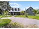 Stately home with a gravel driveway, featuring a well-manicured lawn and lush landscaping at 9905 Skylark Ln, Groveland, FL 34736