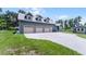 Spacious three-car garage adjacent to a well-kept lawn and an additional storage shed at 9905 Skylark Ln, Groveland, FL 34736