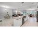 Open-concept kitchen featuring a granite island, stainless steel sink and an adjacent living area at 9905 Skylark Ln, Groveland, FL 34736