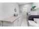 Well-organized laundry room featuring granite countertops, modern appliances, storage cabinets and bright lighting at 9905 Skylark Ln, Groveland, FL 34736