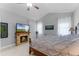 Bedroom featuring vaulted ceiling with fan, stone fireplace and hearth, and two windows at 9905 Skylark Ln, Groveland, FL 34736