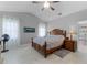 Main bedroom featuring a ceiling fan, two windows, and a decorative bed at 9905 Skylark Ln, Groveland, FL 34736