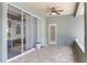 Covered back patio area with ceiling fan and sliding glass doors to the indoor living area at 9905 Skylark Ln, Groveland, FL 34736