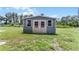 Exterior view of the backyard storage shed with double doors and windows at 9905 Skylark Ln, Groveland, FL 34736