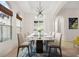 Open-concept dining room with a modern chandelier, travertine floors, and large windows with woven blinds at 9930 Santa Barbara Ct, Howey In The Hills, FL 34737