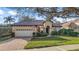 Charming single-story home featuring a tile roof, brick driveway and manicured lawn at 9930 Santa Barbara Ct, Howey In The Hills, FL 34737