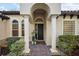 Inviting front entrance with arched columns, a brick walkway, and manicured landscaping creating a welcoming ambiance at 9930 Santa Barbara Ct, Howey In The Hills, FL 34737