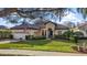 Charming single-story home featuring a tile roof, lush landscaping, and an inviting front yard with mature trees at 9930 Santa Barbara Ct, Howey In The Hills, FL 34737