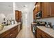 Well-lit kitchen featuring stainless steel appliances, tile flooring, and wooden cabinetry at 9930 Santa Barbara Ct, Howey In The Hills, FL 34737