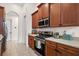 Kitchen area features stainless steel appliances, wood cabinets and tile floors at 9930 Santa Barbara Ct, Howey In The Hills, FL 34737