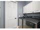 Modern laundry room with front-loading machines and white cabinets at 9930 Santa Barbara Ct, Howey In The Hills, FL 34737