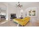 Bright living room with tile flooring, columns, ceiling fan, and yellow sofa at 9930 Santa Barbara Ct, Howey In The Hills, FL 34737