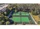 Overhead view of well-maintained tennis courts surrounded by trees and manicured landscaping at 9930 Santa Barbara Ct, Howey In The Hills, FL 34737