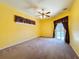 Bedroom featuring bright yellow walls, curtains, ceiling fan, and a sliding door leading to outdoor pool at 100 Grand Reserve Dr, Davenport, FL 33837