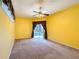 A bright bedroom with yellow walls featuring curtains, a ceiling fan, and a view of the pool at 100 Grand Reserve Dr, Davenport, FL 33837