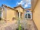 Inviting home exterior featuring an arched entryway and meticulously maintained landscaping at 100 Grand Reserve Dr, Davenport, FL 33837