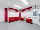 Clean garage with ample storage solutions including custom red cabinets and a workbench area for projects and organization at 100 Grand Reserve Dr, Davenport, FL 33837