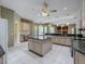 Expansive kitchen with a large island, ceiling fans, a built-in desk and neutral-toned cabinetry at 100 Grand Reserve Dr, Davenport, FL 33837