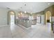 Open kitchen featuring a center island, breakfast bar, arched doorways and light colored cabinetry at 100 Grand Reserve Dr, Davenport, FL 33837