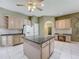 Open-concept kitchen with island, light cabinetry, pantry, granite countertops, and a built-in desk area at 100 Grand Reserve Dr, Davenport, FL 33837