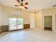 An inviting living room space featuring tile flooring, ceiling fan and an arch window at 100 Grand Reserve Dr, Davenport, FL 33837