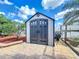 Attractive backyard shed with double doors, decorative windows, and paved surroundings at 100 Grand Reserve Dr, Davenport, FL 33837