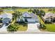 Bright home with well-kept landscaping and a long drive; a beautiful golf course is visible in the background at 1044 Alcove Loop, The Villages, FL 32162