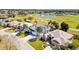 Aerial view of home with a three car garage in golf course community at 1044 Alcove Loop, The Villages, FL 32162