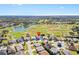 Aerial view of home and community with lush green golf course and pristine lake at 1044 Alcove Loop, The Villages, FL 32162