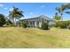 Landscaped backyard featuring a screened lanai and lush lawn at 1044 Alcove Loop, The Villages, FL 32162