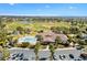 Aerial view of community recreation center and pool nestled among palm trees at 1044 Alcove Loop, The Villages, FL 32162