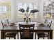 Bright dining area with large windows, plantation shutters, and an elegant wooden table set for four at 1044 Alcove Loop, The Villages, FL 32162