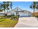 Charming one-story home with a three-car garage and a well-manicured lawn at 1044 Alcove Loop, The Villages, FL 32162