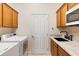 Well-equipped laundry room features modern appliances and ample cabinetry at 1044 Alcove Loop, The Villages, FL 32162