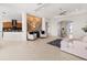 Spacious living room featuring tile flooring and an accent wall, flowing into the kitchen at 1044 Alcove Loop, The Villages, FL 32162